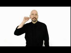 a bald man in black shirt posing for the camera