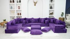 a large purple couch sitting on top of a white rug