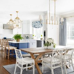 a dining room table and chairs in a white kitchen with blue accents on the walls