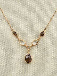 Gold:  9ct Weight:  3.1 grams Gemstone:  Smoky quartz, Rock quartz Size:  16 inches to 18 inches Condition:  Excellent Vintage Condition A beautiful vintage 9ct gold smoky and rock quartz drop necklace. It features 5 faceted quartz gemstones in a Y shape.  It's lightweight, impactful and catches the eye.  The gems are in excellent condition and sparkle under the light.  The chain is adjustable from 16 inches to 18 inches to allow for different necklines.  The largest quartz stone is 10mmx 8mm. T Bronze Necklace Jewelry, Pirate Core, Different Necklines, Jewelry Bronze, Smoky Quartz Necklace, Quartz Rock, Quartz Gemstones, Bronze Necklace, Wedding Jewellery Necklace