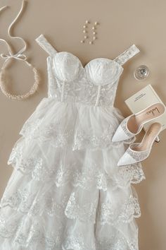 a dress, shoes and jewelry laid out on a table