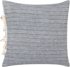 a blue and white striped pillow with tassels on the front, sitting against a white background