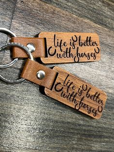 two wooden keychains with engraved words on them