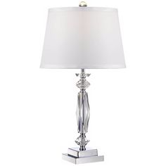 a table lamp with a white shade on it's side and a silver base