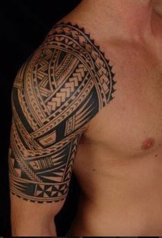 a man with a tattoo on his arm and chest is looking down at the camera