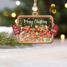 a christmas ornament with gingerbreads and presents hanging from a pine tree