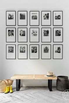 a living room with pictures on the wall and wooden table in front of it,