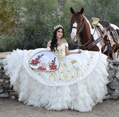 We at Couture Candy recognize the significance of this historic occasion. Because of this, we provide a variety of designs for our Champagne Quinceañera dresses to accommodate a range of interests and preferences. Our selection has everything from dresses that are subtle to those that make a big impact. White And Gold Charro Quince Dress, Virgencita Quince Dress, Gold Charro Dress, Rancho Quinceanera Theme, Charo Quinceanera Dresses, Red Charro Quinceanera Dress, Western Quinceanera Ideas, Charra Quinceanera Dresses, Mariachi Quinceanera Dress