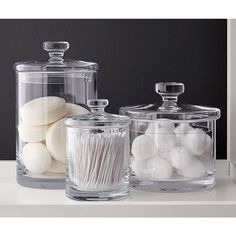 three glass containers with different types of marshmallows in them on a counter