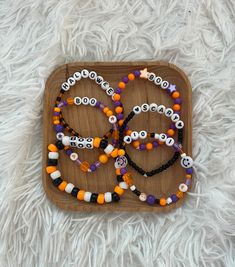 halloween beaded bracelets are arranged on a wooden tray with white furnishing