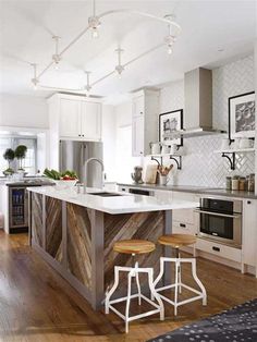 a kitchen with an island and stools in it