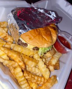 a hamburger and fries on a tray with ketchup