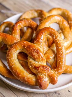 some pretzels are on a white plate and ready to be eaten by someone