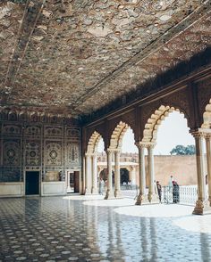 the inside of an ornate building with columns and arches on either side of the room