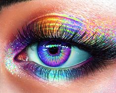 an eye with multicolored eyelashes and long lashes is shown in this image, it appears to be looking into the camera