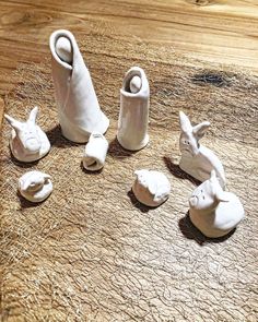 several white ceramic animals sitting on top of a wooden table