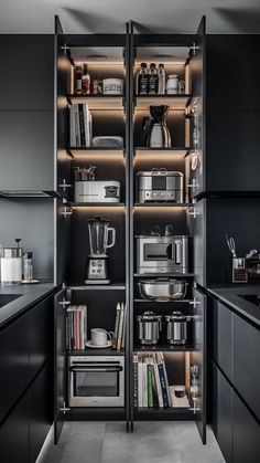 a kitchen with black cabinets and shelves filled with various appliances, including coffee maker, blender, teapot, mixers and other items