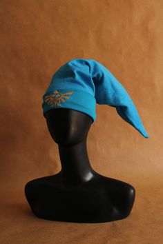 a black mannequin head with a blue hat on it's head and a brown background