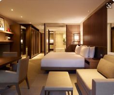 a hotel room with two beds, couches and tables in the middle of it