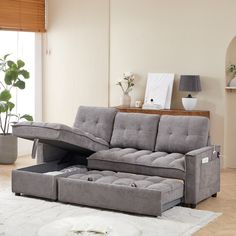 a living room scene with focus on the sectional sofa and footstool that is open