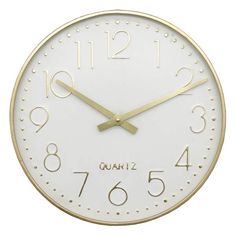 a white clock with gold numbers and numerals on the face is shown against a white background