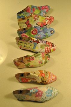 four pairs of shoes are lined up on the counter top, one is decorated with flowers and butterflies