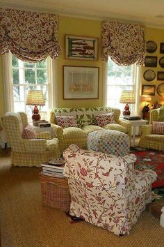 a living room filled with lots of furniture next to a window covered in valance