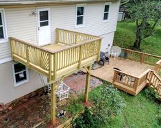 an elevated deck with steps leading up to the back door and stairs down to the second floor