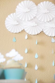 paper umbrellas hanging from the side of a wall with raindrops on it