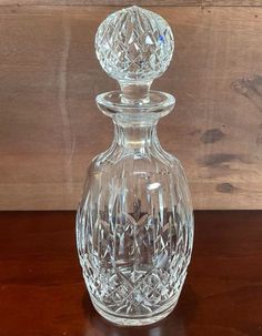 a clear glass decanter sitting on top of a wooden table