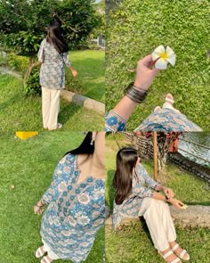 two women sitting on the grass and one is holding a paper flower in her hand