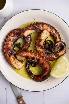 octopus rings with olives and lemon on a white plate