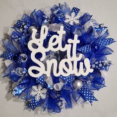 a blue and white wreath with the words let it snow