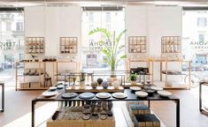 the inside of a store with lots of plates and bowls on display in front of large windows