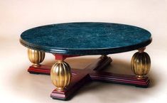 a blue marble topped coffee table sitting on top of a red wooden base with gold accents