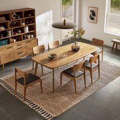 a dining room table and chairs in front of a book shelf with books on it