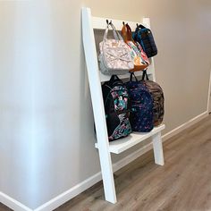 a white shelf filled with luggage next to a wall