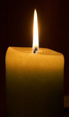 a lit candle is shown in the dark