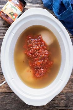 a white bowl filled with soup sitting on top of a wooden table