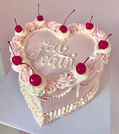 a heart shaped cake with cherries on top