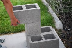 someone is placing cinder blocks into the ground