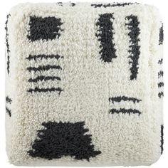 a black and white pillow with an abstract design on the front, along with two different colors