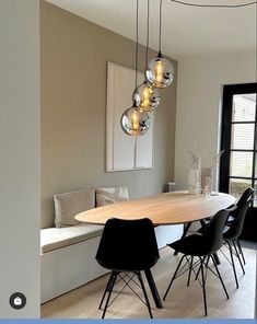 a dining room table with chairs and lights hanging from it's centerpieces