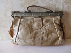 "Vintage doctors bag in tan patchwork leather.  This has a front pocket with a stud fastener and   a top handle.  The fastener is a brass  bar with a sliding hinge at both ends,  there is a zip pocket inside. Good vintage condition. Width;  14\" Depth;  4\" Height;  8\" Handle;  8\" Made in France" Retro Travel Bags With Metal Hardware, Retro Travel Bag With Metal Hardware, Retro Satchel Bag With Metal Hardware, Retro Satchel With Metal Hardware, Vintage Tote Shoulder Bag With Metal Hardware, Retro Shoulder Bag With Metal Hardware, Retro Bags With Brass Hardware For Daily Use, Retro Travel Satchel With Brass Hardware, Beige Satchel Bag With Brass Hardware