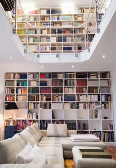 a living room filled with lots of furniture and bookshelves covered in bookcases