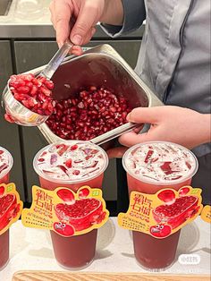 a person is scooping pomegranate into cups