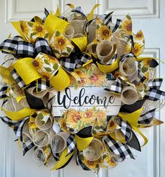 a yellow and black welcome wreath with sunflowers