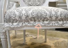 a white chair with a gray and white damask upholstered back