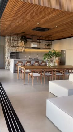 an open living room and dining area with wooden ceiling