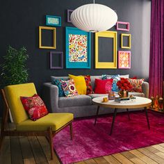 a living room filled with furniture and colorful pictures on the wall above it's coffee table